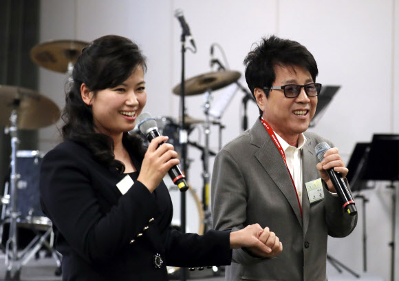 가수 조용필(오른쪽)과 현송월 북한 삼지연관현악단장이 만찬장에서 손을 잡고 함께 노래하고 있다. 연합뉴스