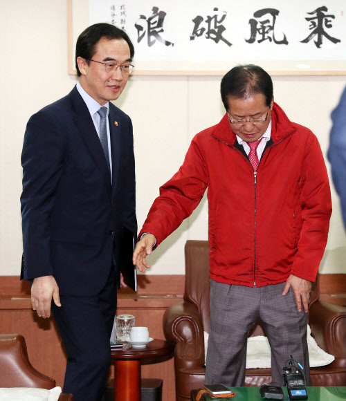 자유한국당 홍준표 대표가 30일 오후 서울 여의도 당사에서 4.27 남북정상회담 관련 현안보고를 위해 방문한 조명균 통일부 장관과 인사 후 자리에 앉고 있다. 연합뉴스