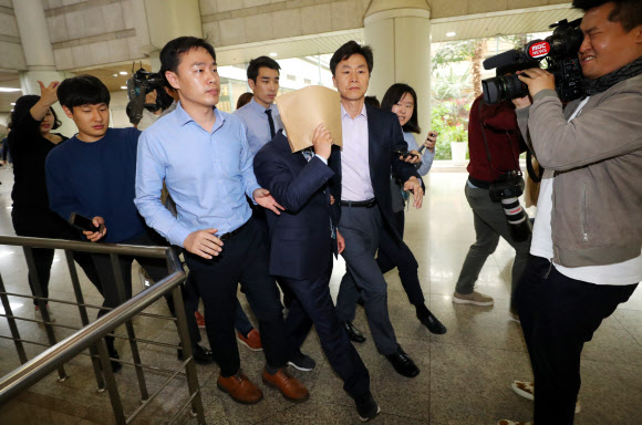 ’서류봉투로 얼굴을 가리며 ’