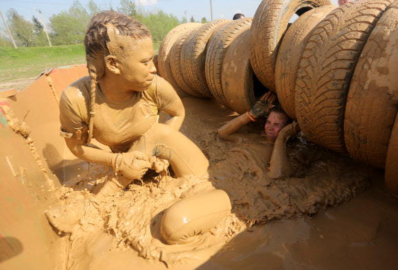 1일(현지시간) 벨라루스의 민스크에서 열린 ‘Bison race’ 익스트림 런에 참여한 참가자들이 진흙을 통과하고 있다. EPA 연합뉴스