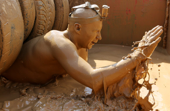 1일(현지시간) 벨라루스의 민스크에서 열린 ‘Bison race’ 익스트림 런에 참여한 참가자들이 진흙을 통과하고 있다. EPA 연합뉴스