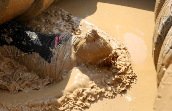 1일(현지시간) 벨라루스의 민스크에서 열린 ‘Bison race’ 익스트림 런에 참여한 참가자들이 진흙을 통과하고 있다. EPA 연합뉴스