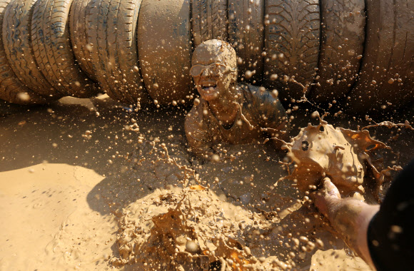 1일(현지시간) 벨라루스의 민스크에서 열린 ‘Bison race’ 익스트림 런에 참여한 참가자들이 진흙을 통과하고 있다. EPA 연합뉴스