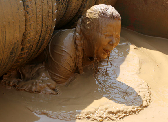 1일(현지시간) 벨라루스의 민스크에서 열린 ‘Bison race’ 익스트림 런에 참여한 참가자들이 진흙을 통과하고 있다. EPA 연합뉴스