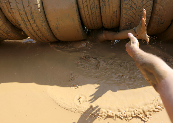 1일(현지시간) 벨라루스의 민스크에서 열린 ‘Bison race’ 익스트림 런에 참여한 참가자들이 진흙을 통과하고 있다. EPA 연합뉴스