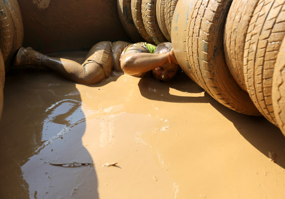 1일(현지시간) 벨라루스의 민스크에서 열린 ‘Bison race’ 익스트림 런에 참여한 참가자들이 진흙을 통과하고 있다. EPA 연합뉴스
