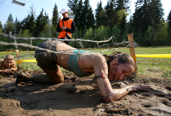 1일(현지시간) 벨라루스의 민스크에서 열린 ‘Bison race’ 익스트림 런에 참여한 참가자들이 진흙을 통과하고 있다. EPA 연합뉴스