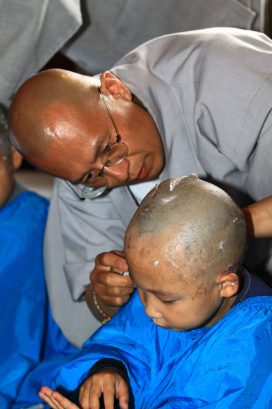 부처님 오신 날을 앞두고 3일 설악산 신흥사에서 열린 동자승 단기출가 수계법회에 참가한 지역 불교유치원 어린이들이 삭발하고 있다.  연합뉴스