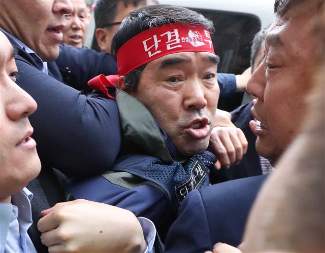 서울 마포대교를 점거하고 불법집회를 주도한 혐의로 구속 된 뒤 잠적한 건설노조 장옥기 위원장이 구속영장 집행기한을 9일 남긴 3일 서울 영등포구 건설노조 사무실에서 나와 자진 출석하고 있다.  뉴스1