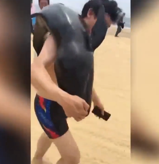 해변가로 밀려온 돌고래 들고 가는 몰지각한 남성 모습(유튜브 영상 캡처)