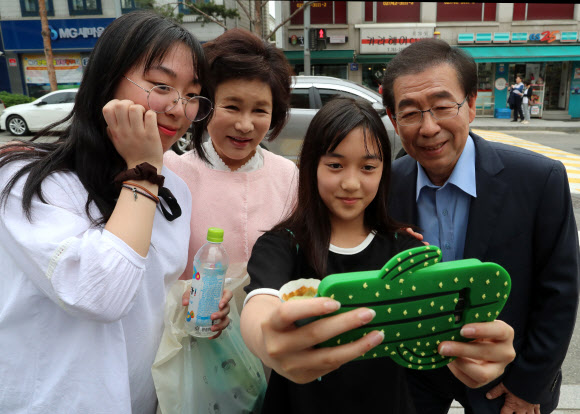 더불어민주당 서울시장 후보인 박원순(오른쪽 첫 번째) 시장과 부인 강난희(세 번째)씨가 종로구 가회경로당을 방문하러 가던 중 시민들과 함께 사진을 찍고 있다.  연합뉴스