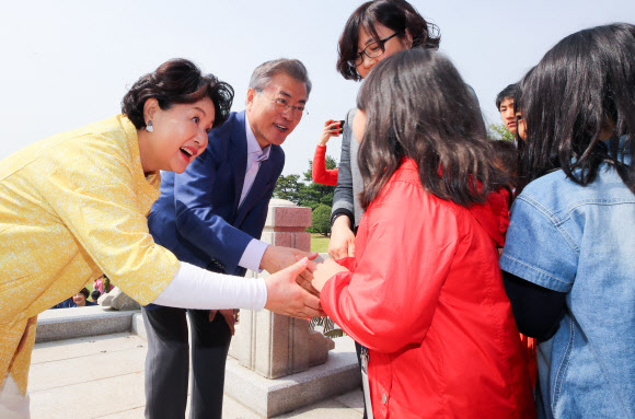 문재인 대통령과 부인 김정숙 여사가 어린이날인 5일 오전 도서?벽지 지역과 접경 지역의 초등학교에 다니는 어린이들을 청와대로 초청해 반갑게 인사하고 있다. 2018.5.5 연합뉴스.