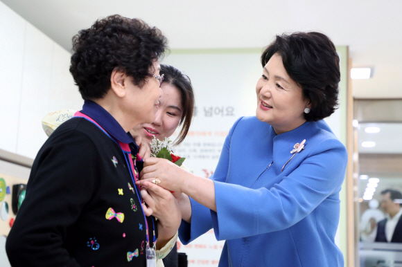 김정숙 여사가 8일 어버이날을 맞아 경기도 남양주 와부읍에 소재한 치매안심센터를 방문해 한 어르신에게 카네이션을 달아주고 있다. 2018.5.8청와대 제공