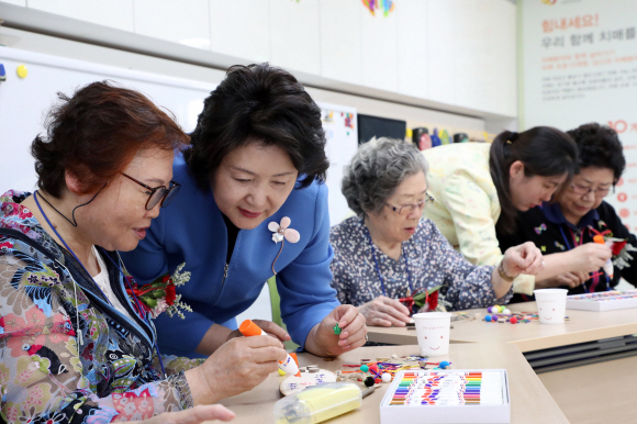 김정숙 여사가 8일 어버이날을 맞아 경기도 남양주 와부읍에 소재한 치매안심센터를 방문해 인지 재활프로그램에 참여한 어르신들과 함께 가훈판을 꾸미고 있다. 2018.5.8청와대 제공