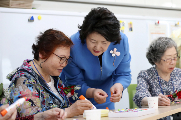 김정숙 여사가 8일 어버이날을 맞아 경기도 남양주 와부읍에 소재한 치매안심센터를 방문해 인지 재활프로그램에 참여한 어르신들과 함께 가훈판을 꾸미고 있다. 2018.5.8청와대 제공