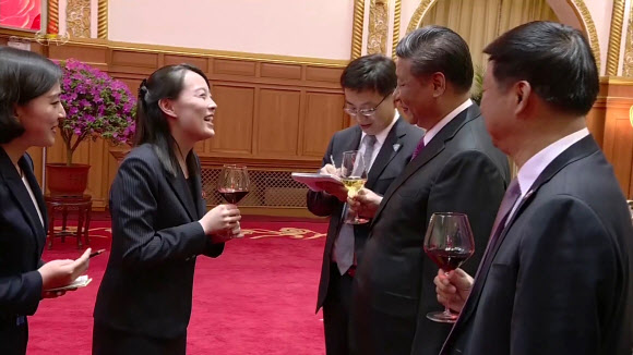 북한 조선중앙TV가 9일 오후 방영한 김정은 국무위원장의 중국 랴오닝(遼寧)성 다롄(大連) 방문 기념연회 영상에서 김여정 노동당 제1부부장이 와인잔을 손에 들고 시진핑 중국 국가주석과 웃으며 이야기를 나누고 있다.  연합뉴스