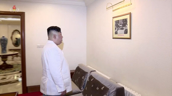 북한 조선중앙TV가 9일 오후 방영한 김정은 국무위원장의 중국 랴오닝(遼寧)성 다롄(大連) 방문 영상에서 다롄의 방추이다오(棒槌島)를 찾은 김 위원장이 김일성 주석의 과거 사진을 바라보고 있다.  연합뉴스