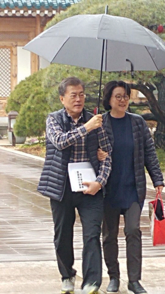 크리스마스 이브, 문재인 대통령과 김정숙 여사가 관저에서 우산을 쓰고 함께 걷고 있다.17.12.24 청와대제공