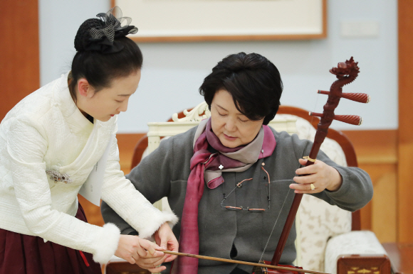 김정숙 여사가 중국 순방 전, 중국의 전통악기인 얼후 연주를 체험하고 있다.17.12.12 청와대제공