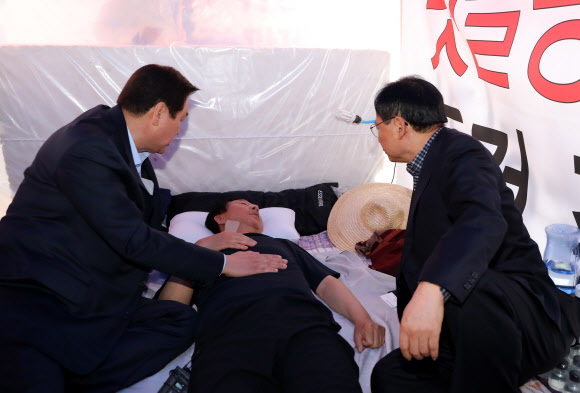 ’드루킹 특검’을 요구하며 국회 앞에서 9일째 단식농성을 이어가고 있는 자유한국당 김성태 원내대표에게 11일 오후 열린 의원총회에서 중단을 결정, 김무성 의원이 병원으로 갈것을 권유하고 있다.  연합뉴스