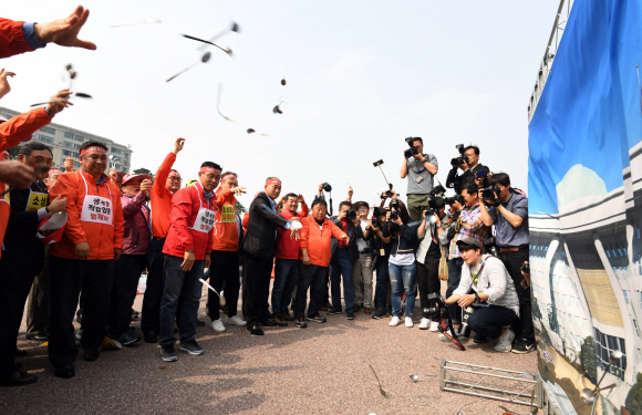 14일 서울 여의도 공원에서 열린 소상공인 생존권 보장 결의대회에서 참석자들이 국회 사진을 향해 숟가락을 던지는 퍼포먼스를 하고 있다. 2018. 5. 14. 박윤슬 기자 seul@seoul.co.kr