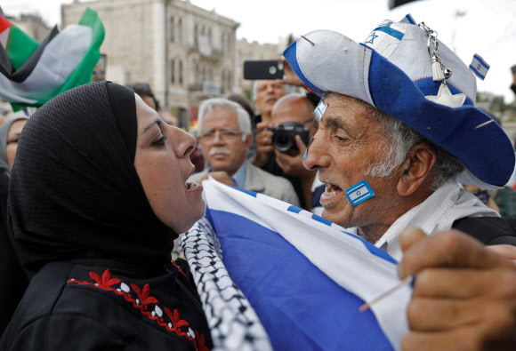 이스라엘이 요르단 지역이었던 동예루살렘을 점령한 기념일인 ‘예루살렘의 날’이기도 한 14일(현지시간) 기념 행사에 참여한 이스라엘 남성(오른쪽)이 팔레스타인 여성과 말다툼을 벌이고 있다. 예루살렘 AFP 연합뉴스