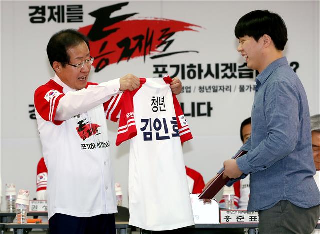 홍준표 자유한국당 대표가 15일 오전 서울 여의도 당사에서 열린 6·13 지방선거 일자리! 설자리! 살자리! 선거대책위원회 발대식 및 1차 회의에서 김인호 공동 중앙선거대책위원장에게 임명장과 함께 유니폼을 전달하고 있다.  뉴스1