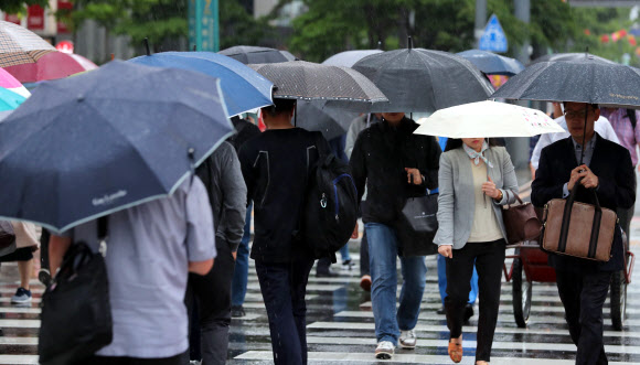 전국적으로 비가 내리는 16일 오전 서울 광화문 세종대로 사거리에서 우산을 쓴 출근길 시민들이 발걸음을 옮기고 있다.  연합뉴스