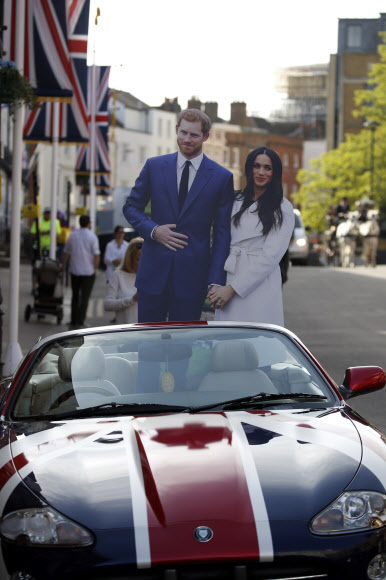 오는 19일(현지시간) 결혼식을 올리는 영국 해리 왕자와 할리우드 여배우 메건 마클의 등신대가 영국 윈저성에 주차된 차에 세워져 있다. AFP 연합뉴스