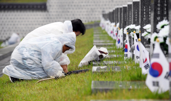 18일 광주 국립 5.18민주묘지에서 열린 ‘제38주년 5.18 민주화 운동 기념식’을 마친 뒤 유가족들이 고인의 묘 앞에서 절하고있다.. 2018. 05. 18 박윤슬 기자 seul@seoul.co.kr