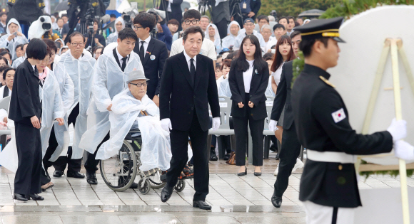 5.18 민주화운동 38주년 기념식이 18일 오전 광주 북구 운정동 국립 5.18민주묘지에서 열렸다. 이낙연 국무총리와 윤상원 열사의 아버지 윤석동(휠체어탄 이) 등이 헌화하기 위해 나오고 있다. 2018. 05. 18 박윤슬 기자 seul@seoul.co.kr