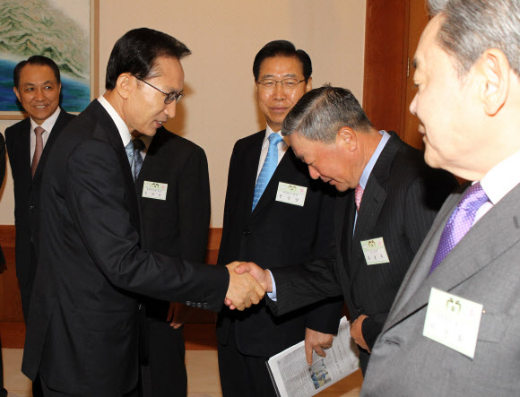 20일 LG그룹 구본무 회장이 숙환으로 별세했다. 사진은 2010년 이명박 대통령이 대기업 대표들과 가진 조찬 간담회에서 구본무 LG그룹 회장과 악수하는 모습.  연합뉴스 자료사진