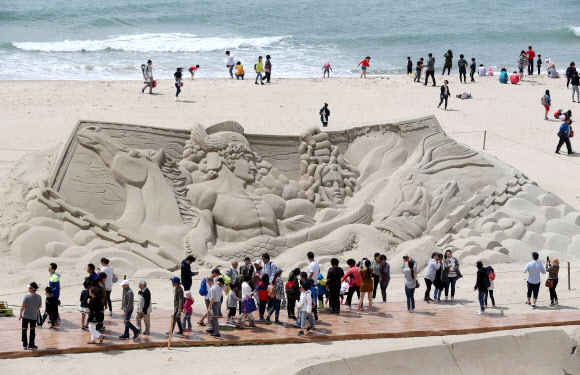 20일 부산 해운대해수욕장에서 열린 2018 해운대모래축제에서 시민들이 모래작품을 감상하고 있다. 올해로 14회째를 맞은 해운대모래축제는 ‘Hero(영웅), 모래로 만나다’를 주제로 22일까지 열린다.  연합뉴스