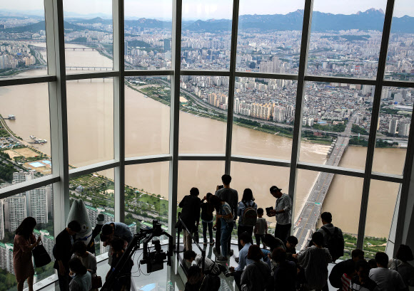 봄장마가 남기고 간 깨끗함이 계속된 20일 오전 서울 송파구 롯데월드타워 전망대 ‘서울 스카이’를 찾은 시민들이 미세먼지 없는 하늘아래 황톳빛으로 변한 한강을 바라보고 있다. 이날 서울의 시정거리는 30Km를 넘었다고 ‘서울 스카이’는 밝혔다. 2018.5,20 연합뉴스