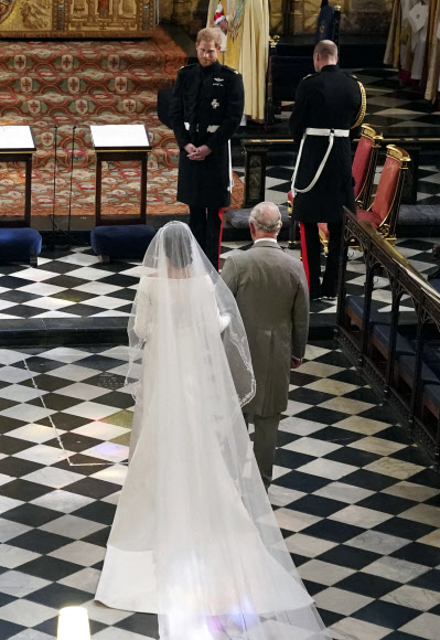 신랑 해리 왕자가 아버지 찰스 왕세자의 손을 잡고 결혼식장으로 들어오는 신부 마클을 활짝 웃으며 맞고 있다. 런던 AP 연합뉴스