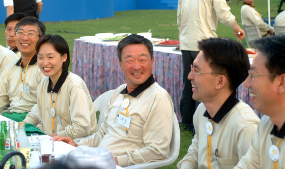 지난 20일 구본무(가운데) LG그룹 회장이 숙환으로 별세했다. 사진은 2002년 5월 구 회장이 사내 행사에서 직원들과 같은 티셔츠를 입고 웃으며 이야기를 나누는 모습.  연합뉴스