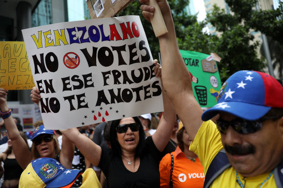 미국 내 베네수엘라 난민들이 20일(현지시간) 플로리다주 마이애미의 베네수엘라 영사관 앞에서 대선에 항의하는 시위를 벌이는 모습.  마이애미 AFP 연합뉴스