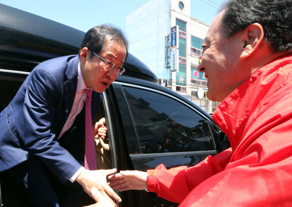 자유한국당 홍준표 대표가 23일 낮 제천시 동문시장을 찾아 6·13 국회의원 제천·단양 재선거 예비후보인 엄태영 전 제천시장과 악수를 하고 있다. 2018.5.23  연합뉴스