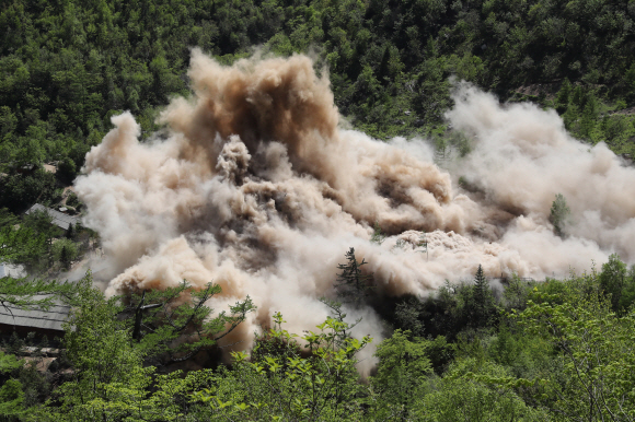24일 북한 핵무기연구소 관계자들이 함경북도 길주군 풍계리 핵실험장 폐쇄를 위한 폭파 작업을 했다. 사진은 지휘소와 건설노동자 막사가 폭파되는 모습.  2018.5.25  사진공동취재단