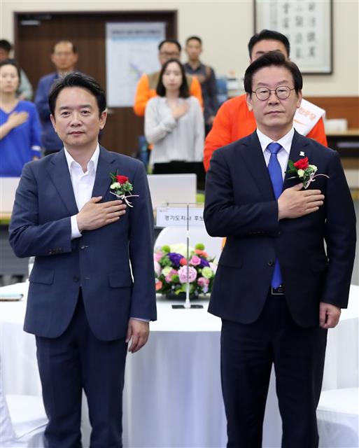 남경필 자유한국당 경기도지사 후보(왼쪽), 이재명 더불어민주당 후보가 25일 오후 경기도 수원시 영통구 경기도선거관리위원회에서 열린 매니페스토 정책선거 실천 협약식에서 국민의례를 하고 있다. 2018.5.25 뉴스1