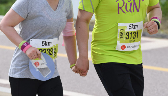 27일 서울 광진구 뚝섬한강공원에서 열린 ‘제2회 롯데 스타일런 마라톤 대회’에서 참가자들이 개성 손을 잡고 달리고 있다. 2018. 5. 27. 박윤슬 기자 seul@seoul.co.kr