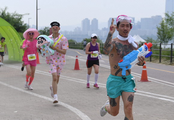27일 서울 광진구 뚝섬한강공원에서 열린 ‘제2회 롯데 스타일런 마라톤 대회’에서 참가자들이 개성 있는 복장을 하고 달리고 있다. 2018. 5. 27. 박윤슬 기자 seul@seoul.co.kr