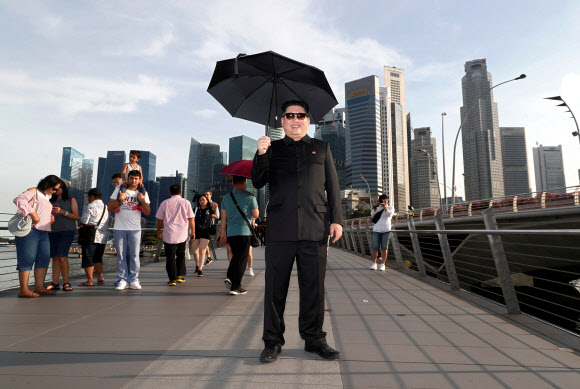 다음 달 12일 북미 정상회담이 싱가포르에서 열리기로 추진되고 있는 가운데 김정은 북한 국무위원장 분장을 한 호주 국적의 중국인인 ‘가짜 김정은’ 하워드가 27일(현지시간) 싱가포르 마리나베이에서 사진을 찍고 있다.  로이터 연합뉴스