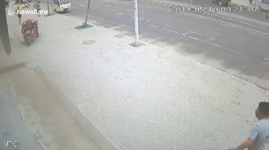 삼륜차 옆에 매달려 있는 아이를 구하기 위해 몸을 던져 막은 한 중국 남성의 영웅적 모습(유튜브 영상 캡처)