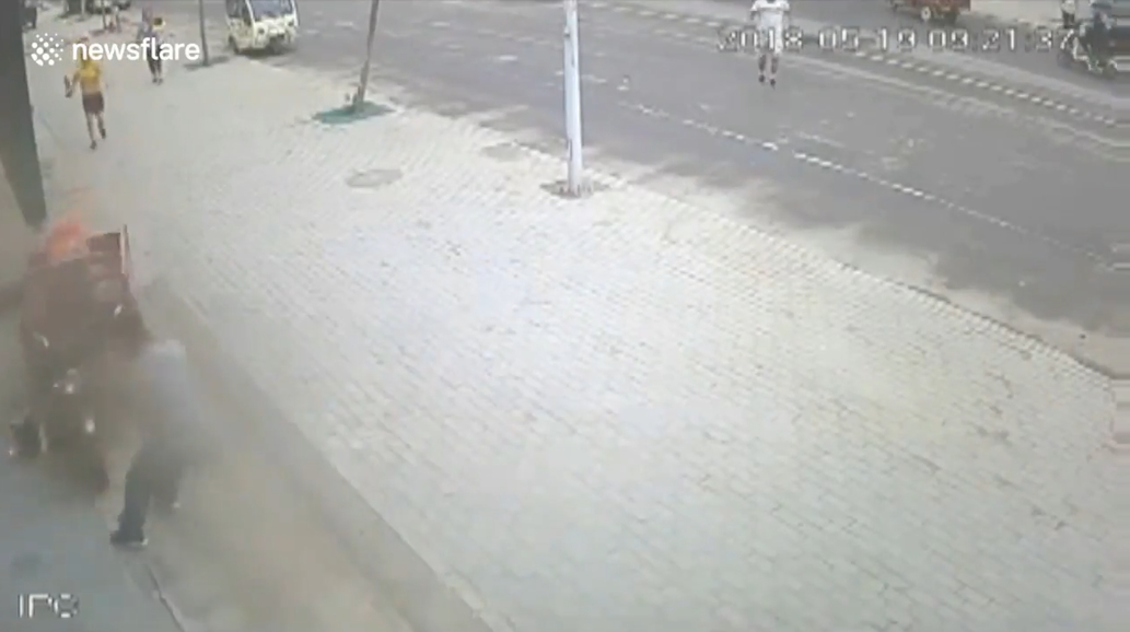 삼륜차 옆에 매달려 있는 아이를 구하기 위해 몸을 던져 막은 한 중국 남성의 영웅적 모습(유튜브 영상 캡처)