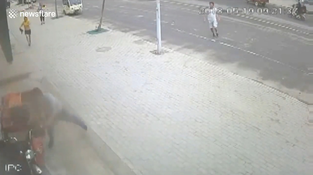 삼륜차 옆에 매달려 있는 아이를 구하기 위해 몸을 던져 막은 한 중국 남성의 영웅적 모습(유튜브 영상 캡처)