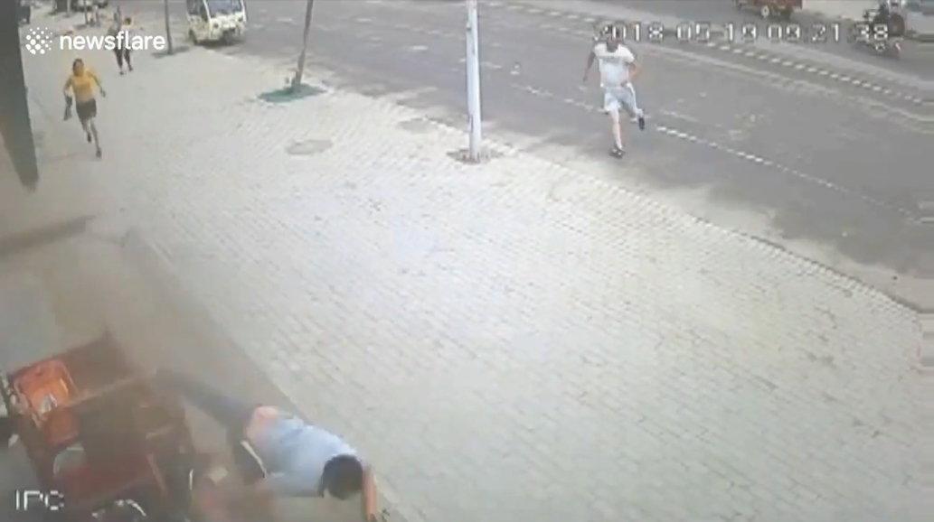 삼륜차 옆에 매달려 있는 아이를 구하기 위해 몸을 던져 막은 한 중국 남성의 영웅적 모습(유튜브 영상 캡처)