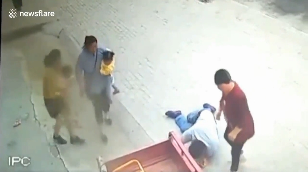 삼륜차 옆에 매달려 있는 아이를 구하기 위해 몸을 던져 막은 한 중국 남성의 영웅적 모습(유튜브 영상 캡처)