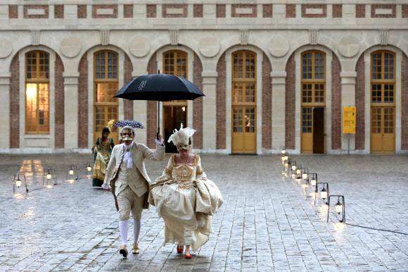 28일(현지시간) 프랑스 파리의 베르사유 궁전에서 열린  ‘페트 갈랑트(fetes galantes)’에 참석한 사람들이 화려한 드레스를 입고 궁전을 누비고 있다. ‘페트 갈랑트’는 베르사유 궁전 거울의 방에서 당시의 가장무도회를 직접 체험해 볼 수 있는 이벤트다.  AFP 연합뉴스