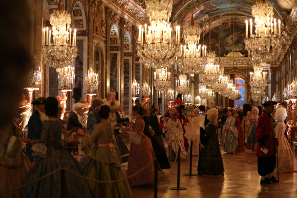 28일(현지시간) 프랑스 파리의 베르사유 궁전에서 열린  ‘페트 갈랑트(fetes galantes)’에 참석한 사람들이 화려한 드레스를 입고 궁전을 누비고 있다. ‘페트 갈랑트’는 베르사유 궁전 거울의 방에서 당시의 가장무도회를 직접 체험해 볼 수 있는 이벤트다.  AFP 연합뉴스